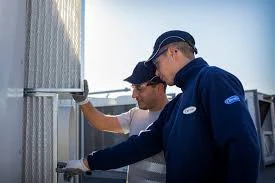 Two technicians inspecting large HVAC equipment